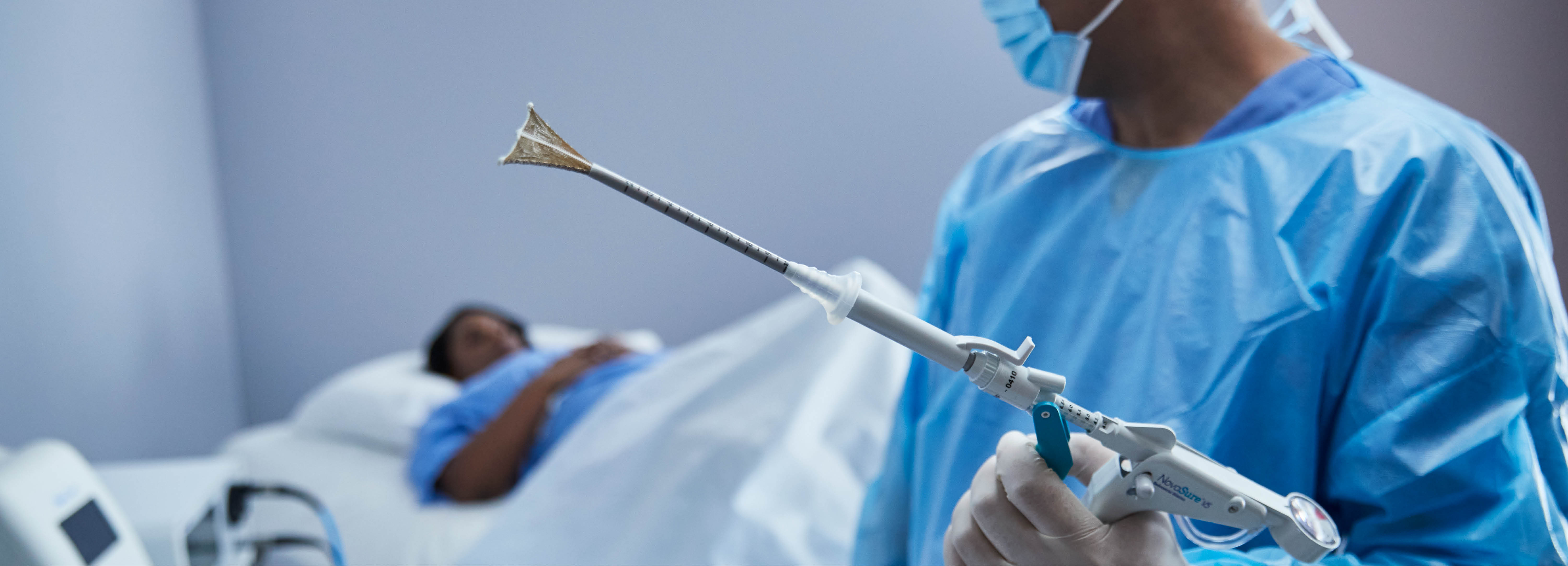 Gloved hand holding medical device in a lab setting.