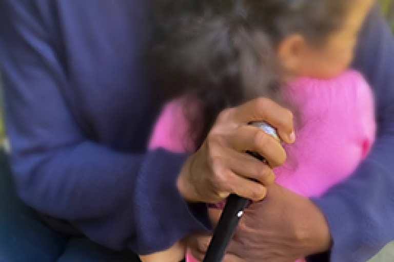 Black grandmother holding cane and hugging young girl