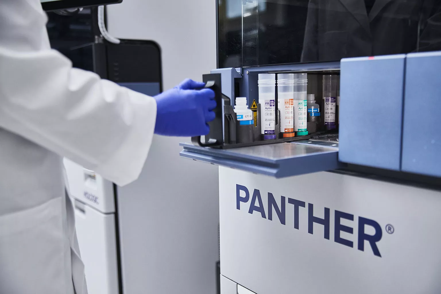 Lab technician works with tube tray in lab setting