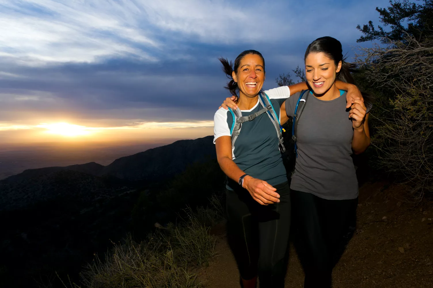 Two women hiking outside at sunrise