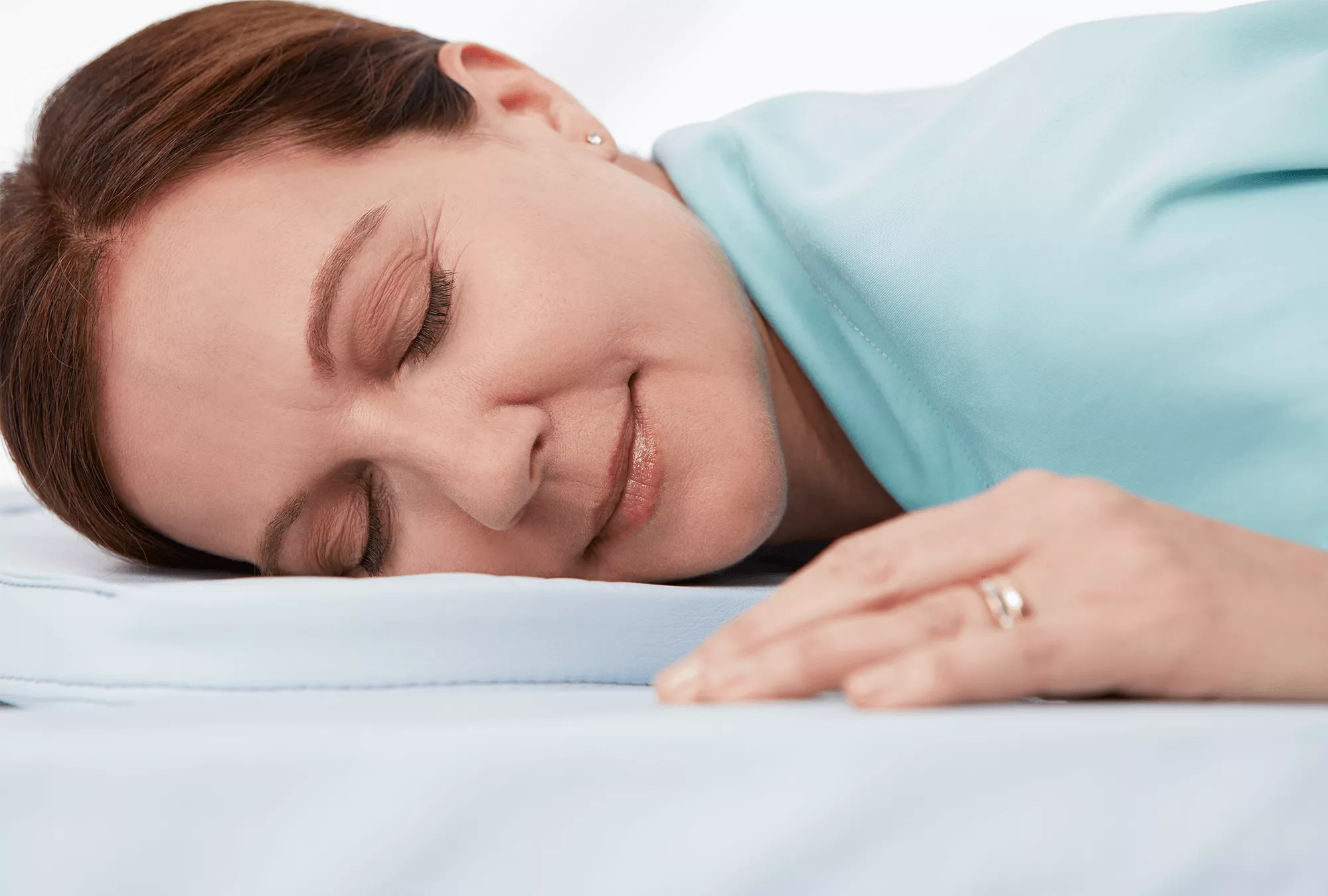 Woman patient lying down on bed comfortably with relaxed smiling expression